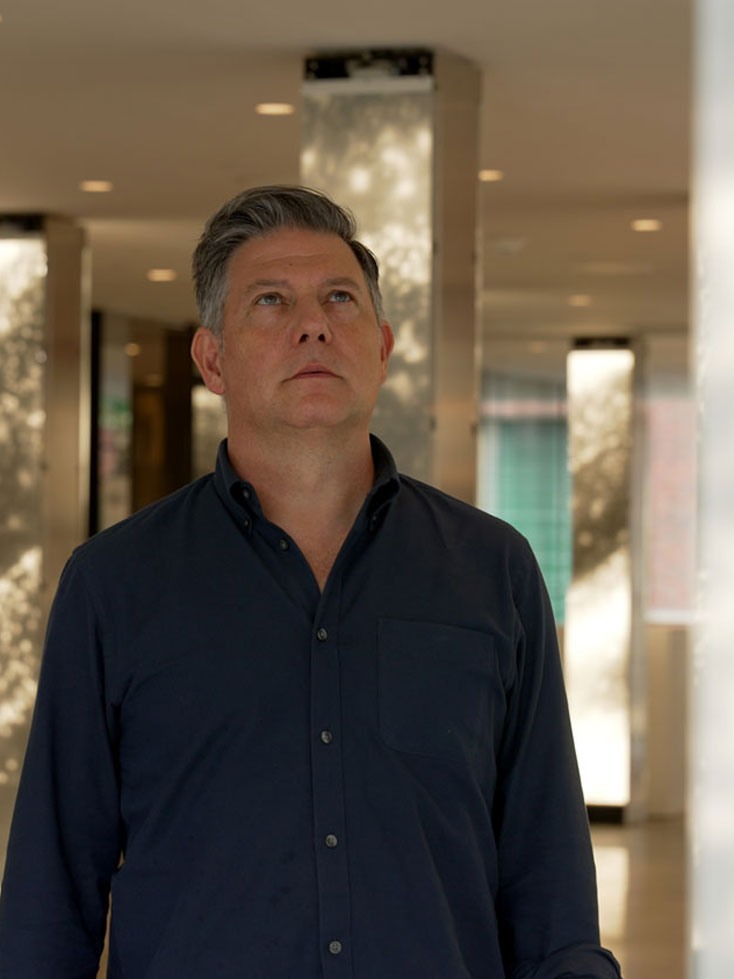 Leo Villareal looking up at an LED light panel