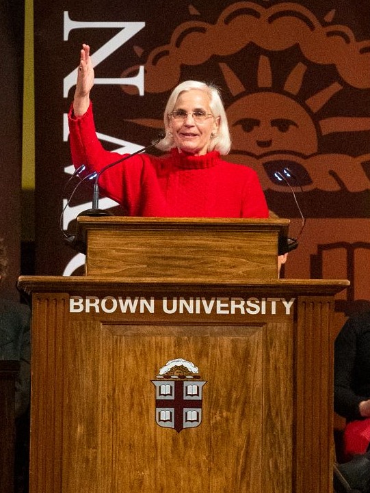 Jeri DeBrohun standing at a podium and gesturing to the audience