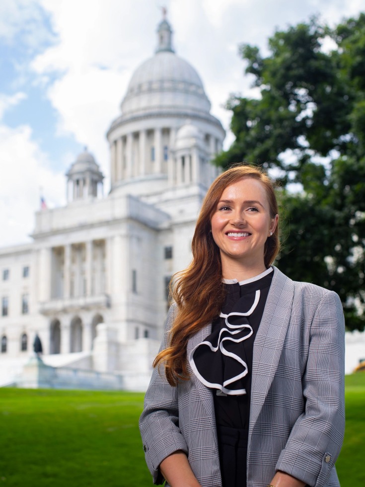 Nathalia poses in the foreground of the State House
