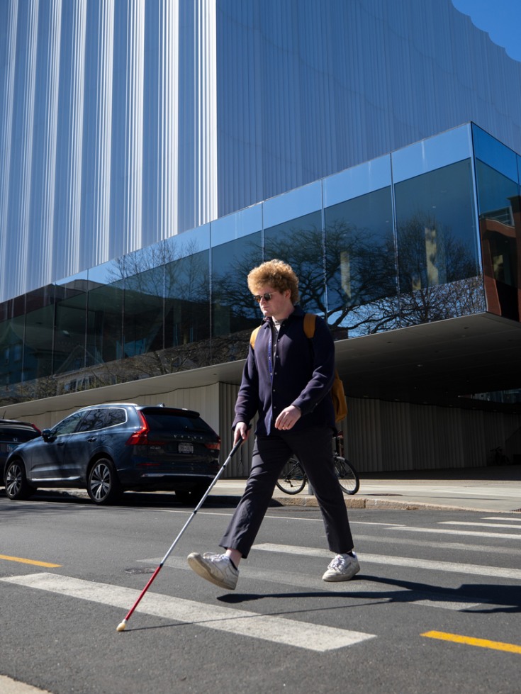 Daniel Solomon uses a cane to cross a street intersection