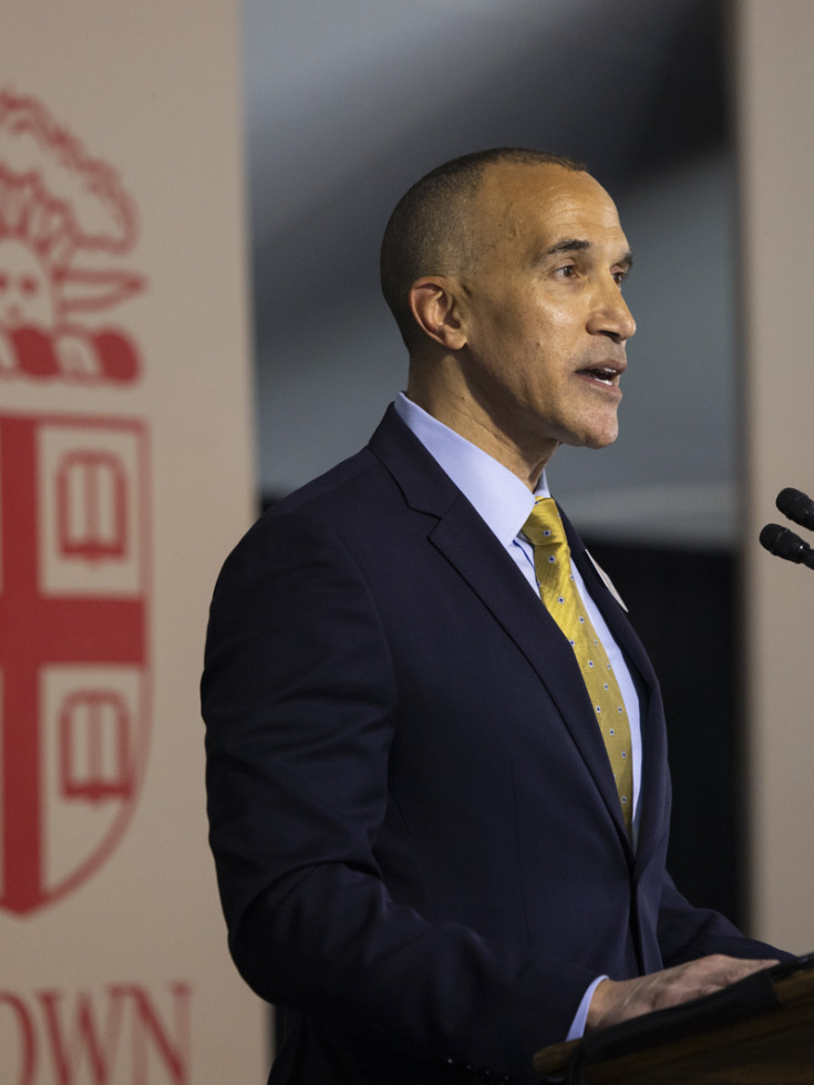 Logan Powell speaks at a podium to a crowd on A Day on College Hill admissions event. 