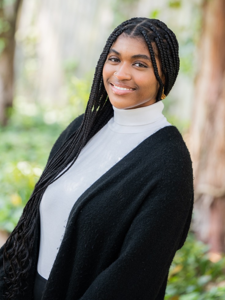 cyprene caines poses for headshot in white turtleneck