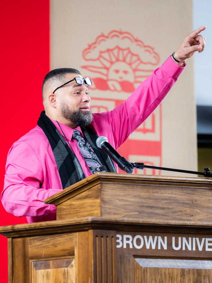 Javier Montanez standing at a podium and pointing upward