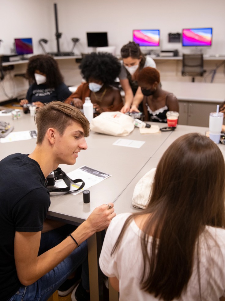 Hlib Burtsev talks to a classmate in a classroom.