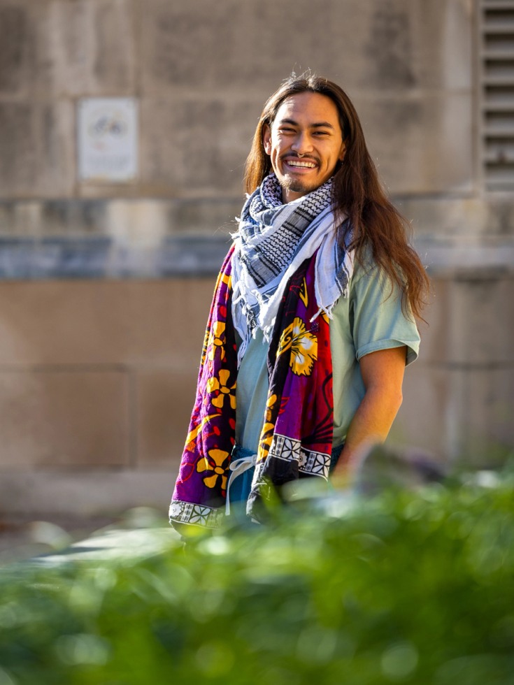 Kaliko smiles at camera, wearing scarfs