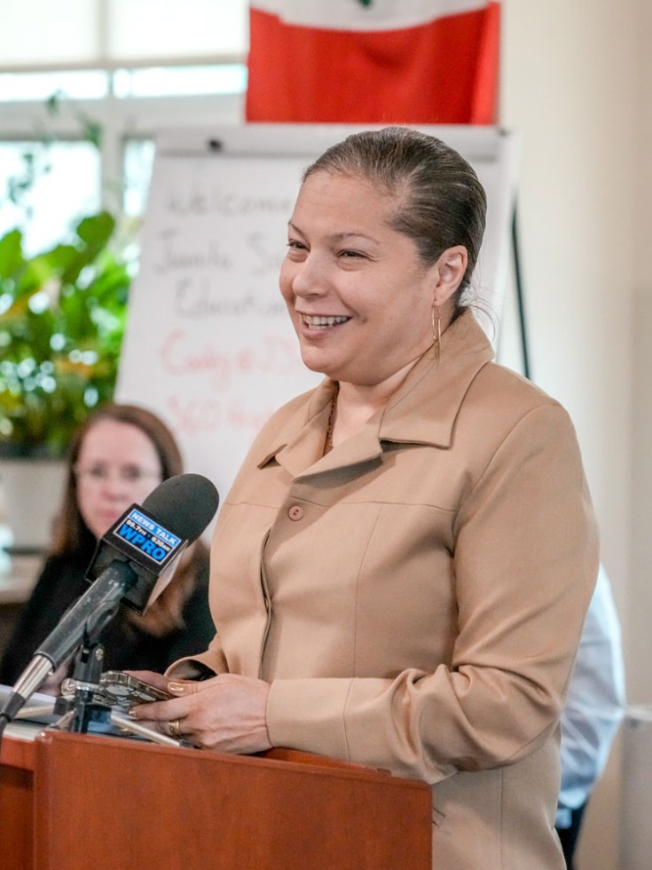 Angelica Infante-Green speaking at a podium