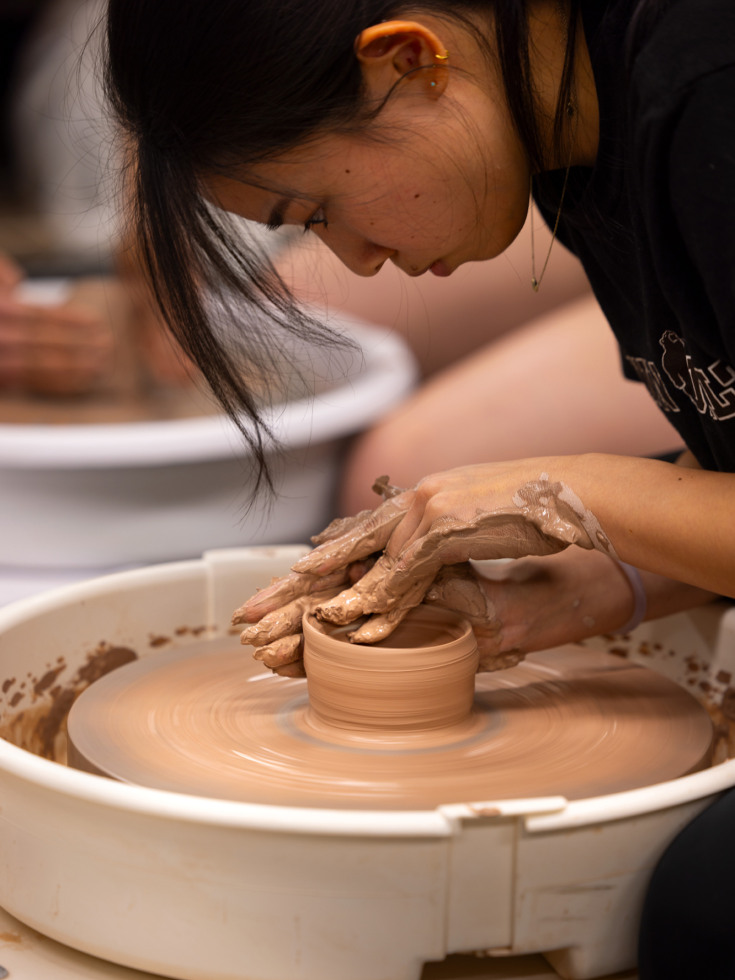 Tina Li works behind the pottery wheel