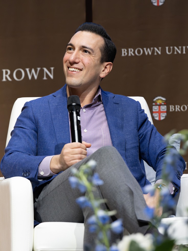 Jamil Zaki sits in chair on stage