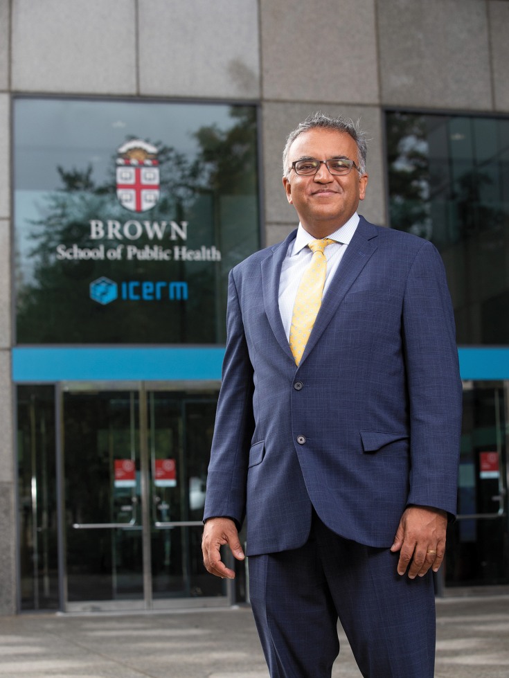 Dr. Jha standing in front of Brown School of Public Health