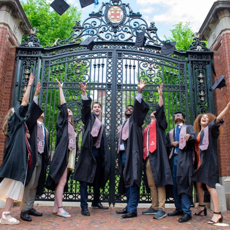 graduates toss up their caps in front of van wickle gates