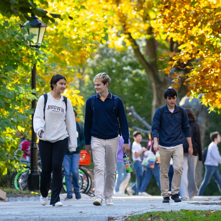Students walking on campus during autumn.