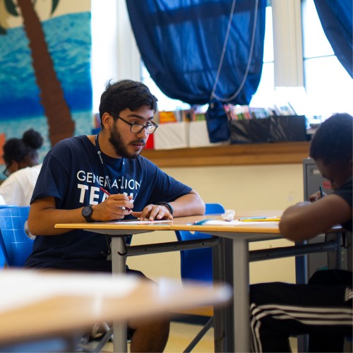 Students at a desk in a classroom.