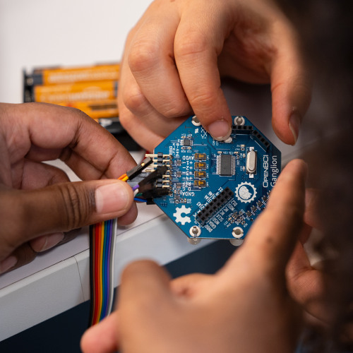 Computer chip held by two sets of hands