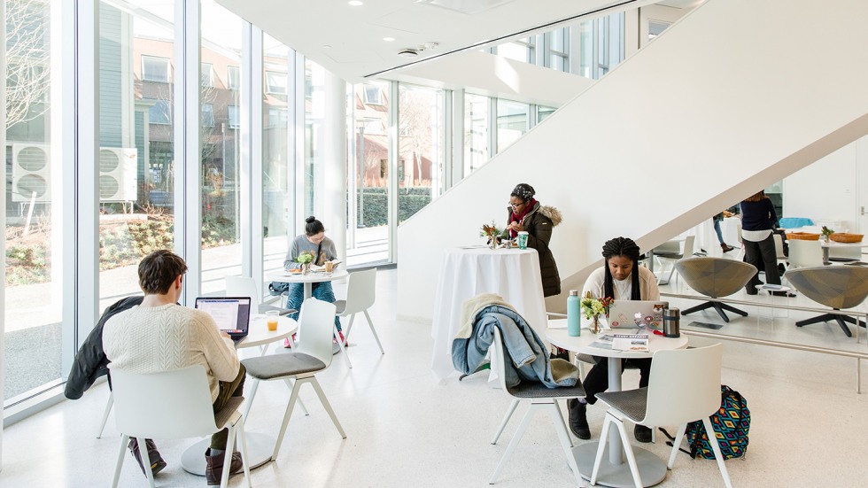 Students studying next to floor to ceiling windows