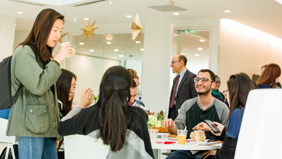 Students at a round table talking and eating