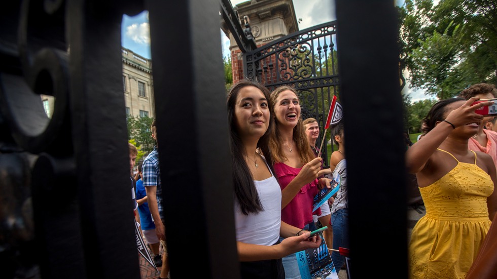 Students with flags processing through Van Wickle gates