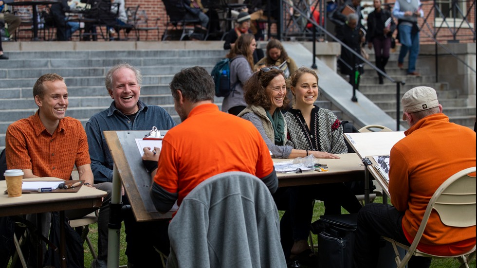 Son, father, mother and daughter getting their caricatures drawn