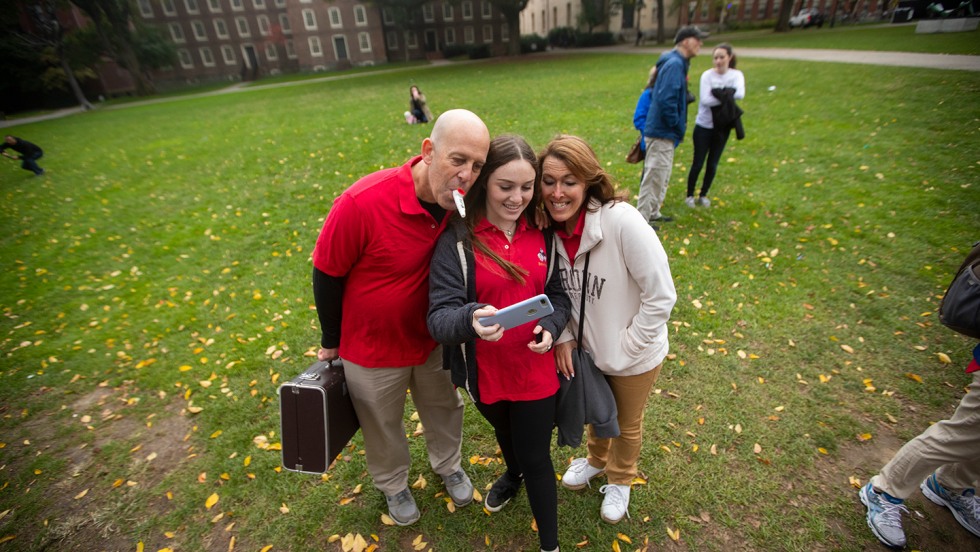 Father, daughter and mother taking a selfie on the green