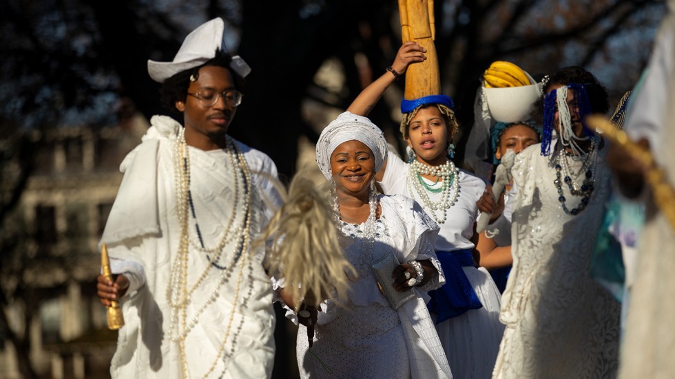 Procession of people wearing white garments and beads