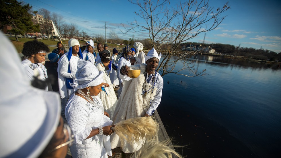 Group of people in white garments at the water's edge