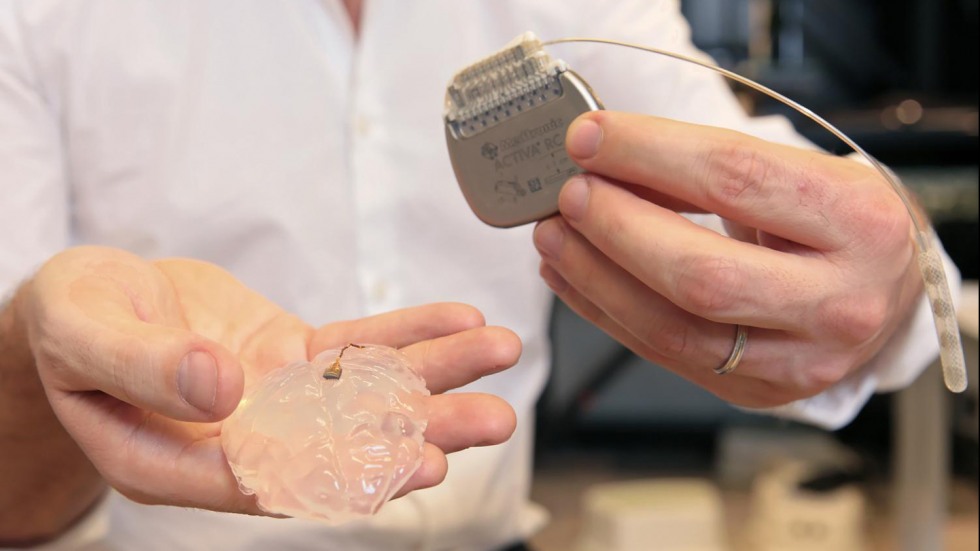 David Borton holding spinal stimulation device