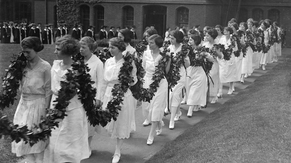 Pembroke students wearing white dresses and ivy garlands