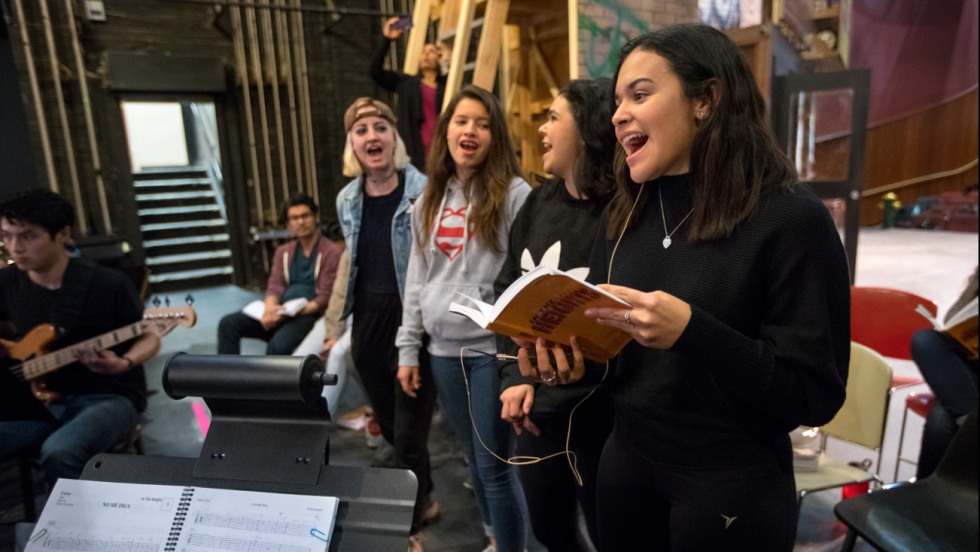 Cast members singing during a rehearsal