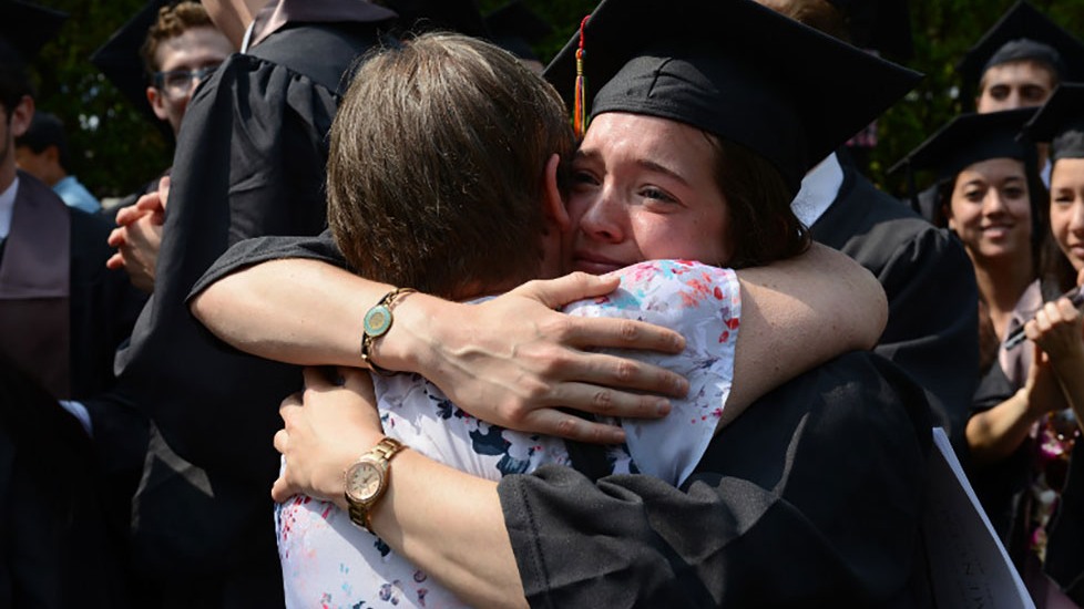 New graduate Maggie Jordan shares a hug 