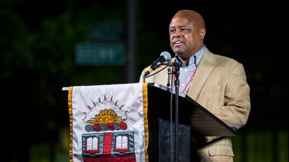 John Robinson talking at a podium