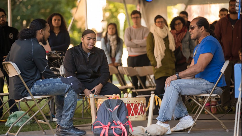 Students sitting around a drum.