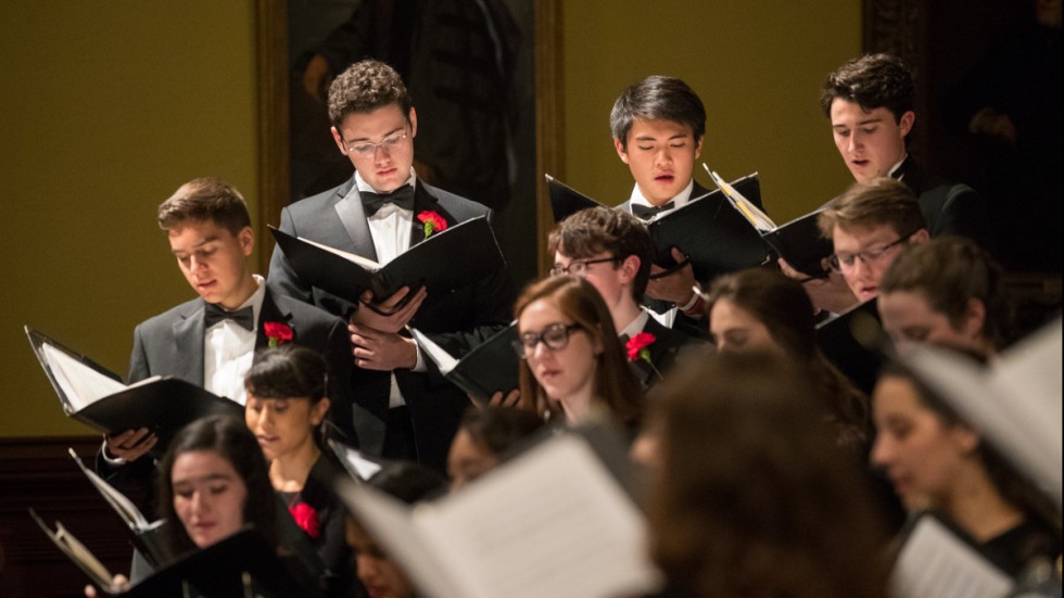 Brown University Chorus members holding music and singing