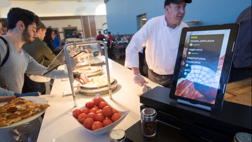 Students getting pizza from the chef