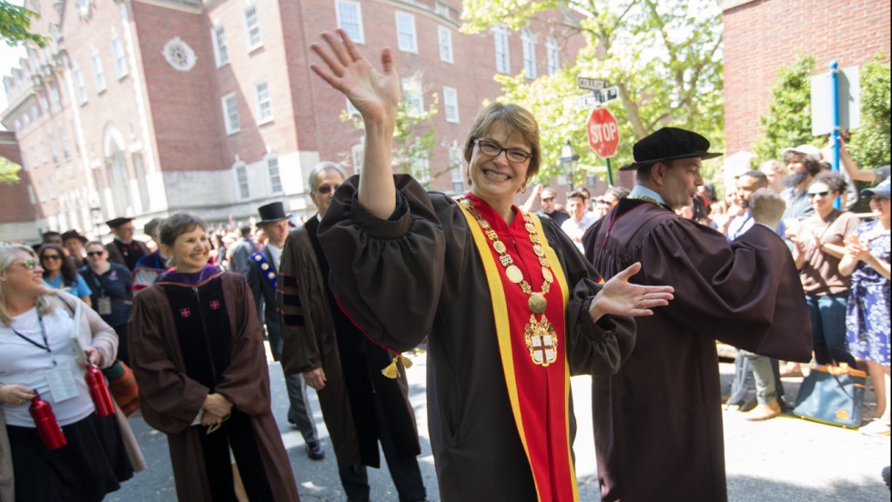 President Paxson in robes waving to camera