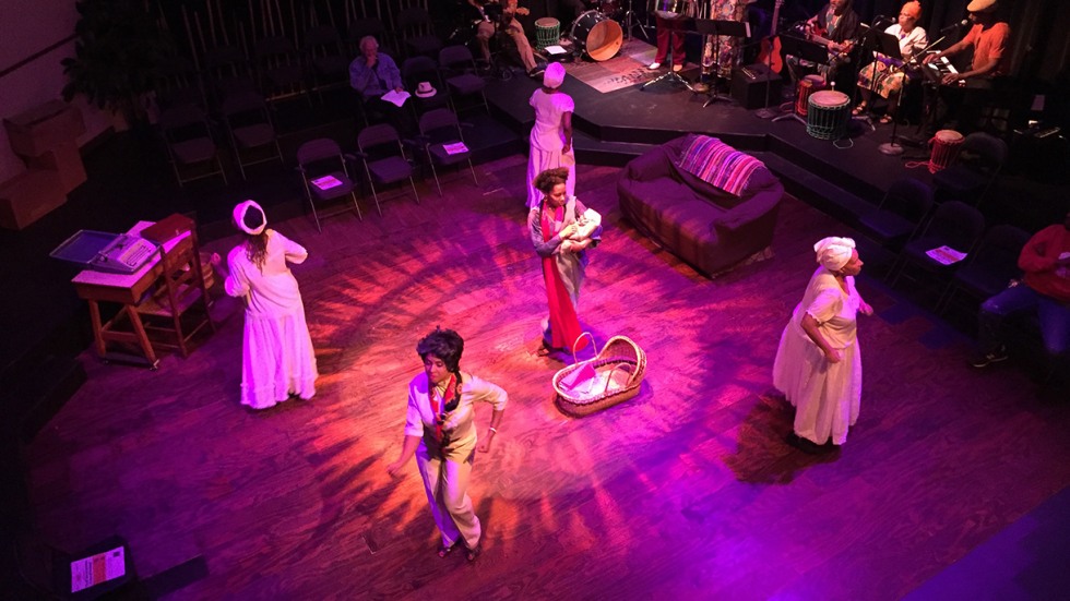 Performers on stage in pink light