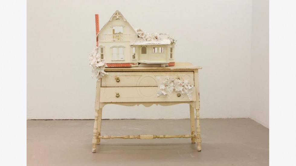 Model of house sitting on top of side table with drawer, ivory, with flower accents