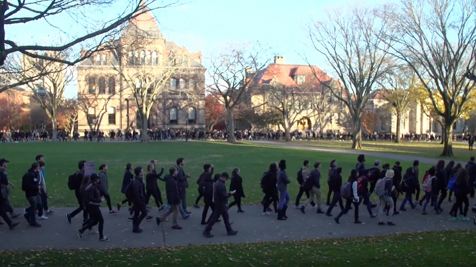 Students walking across campus in long lines