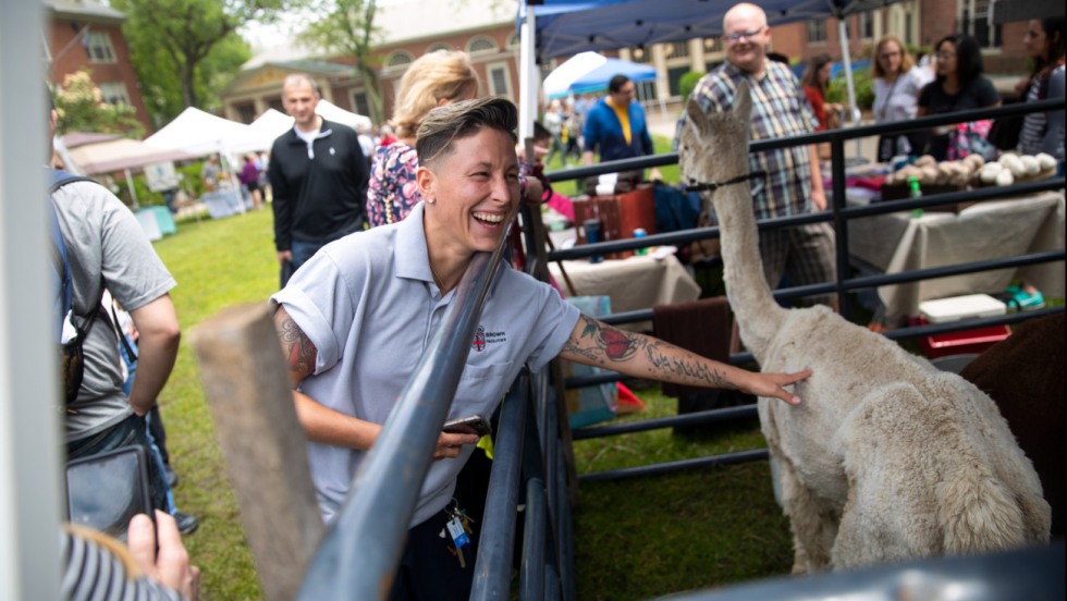 Woman petting an alpaca at Wriston Quad Farmers market