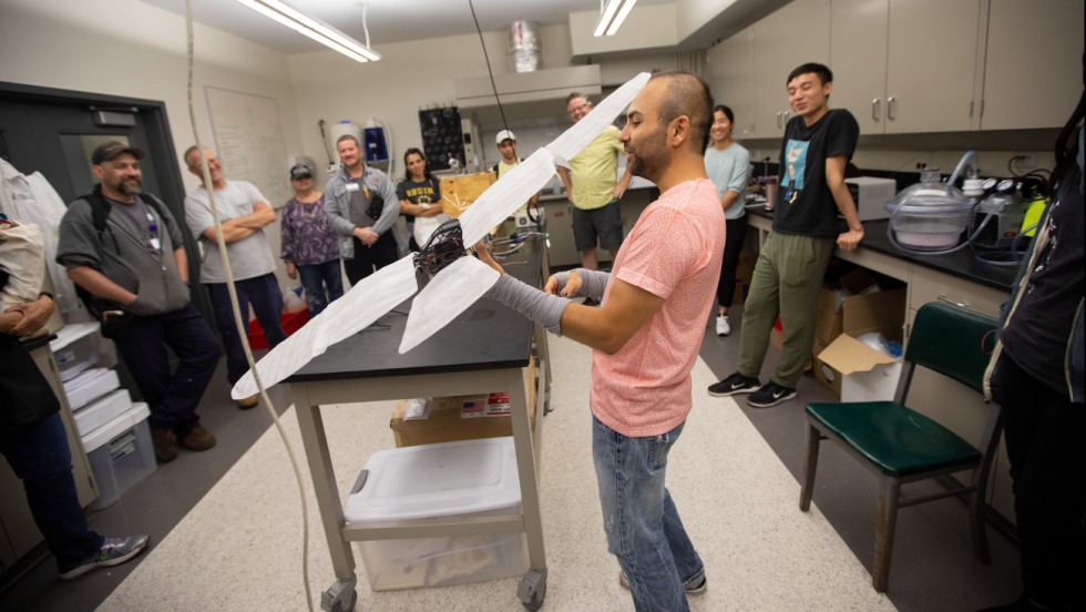 Graduate student Alberto Bortoni showed staff the different machines he and other Brown researchers have made to study flight during the Bats in Action event where staff learned about bat research at Brown.