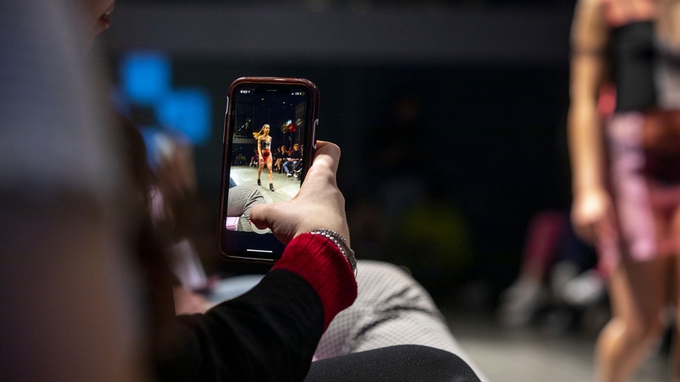 Student with smartphone at F@B Runway Show