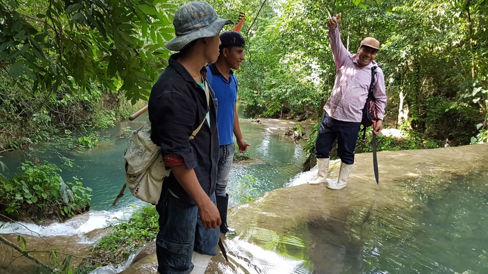 Men walking across the top of a waterfall