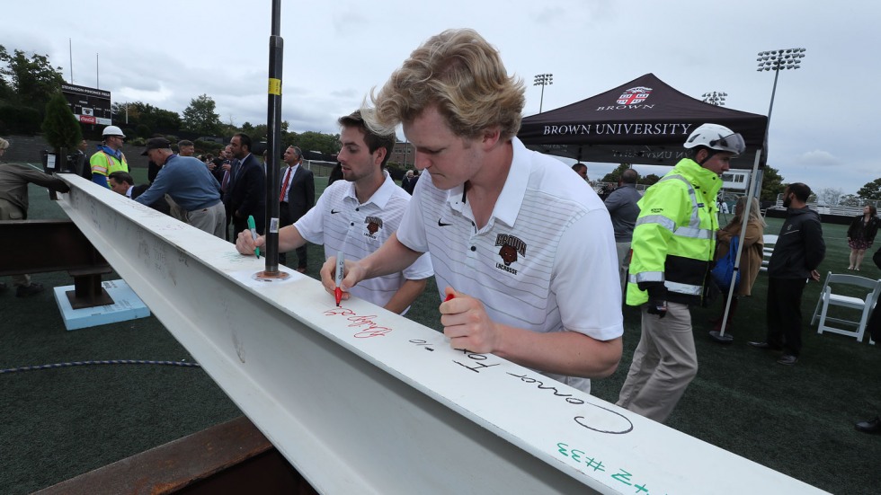 Phil Goss signing a metal beam