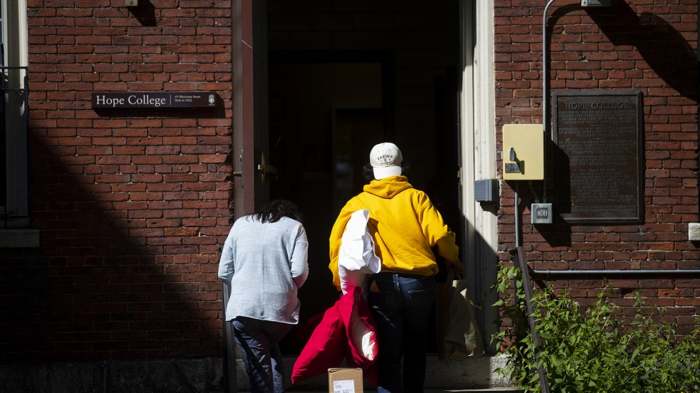 A student moves into his residence hall with help from a family member.