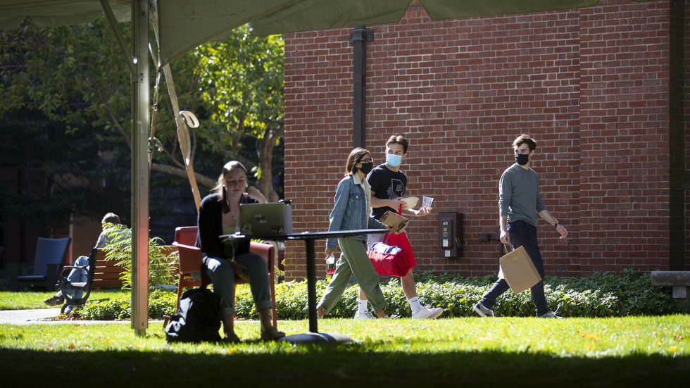 Students walk by a tent on the green at Brown University