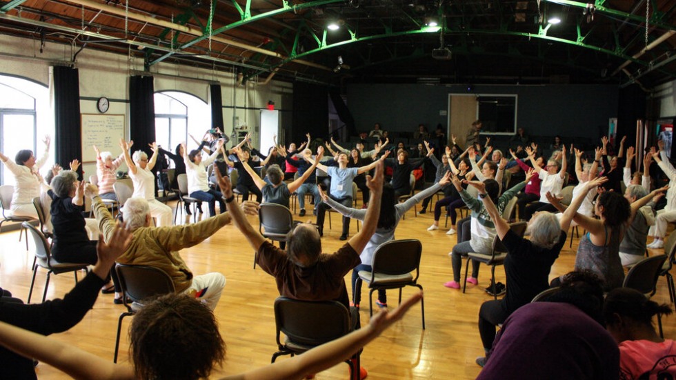 group of people dancing while sitting in chairs