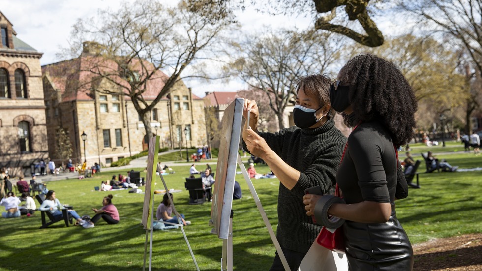 Assistant Vice President for Campus Life Engagement Loc Truong helps Wassa Bagayoko, co-programmer for the Black Heritage Series, set up student artwork at the Black Arts Showcase. This year's showcase featured visual art and performances by dozens of members of the Black student community at Brown.