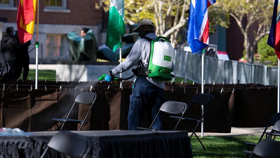 Brown staff member spraying down seats between events