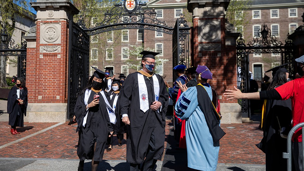 Faculty applauding the master’s and doctoral graduates