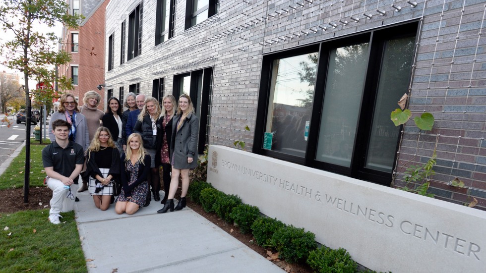 people gathered in front of a concrete sign