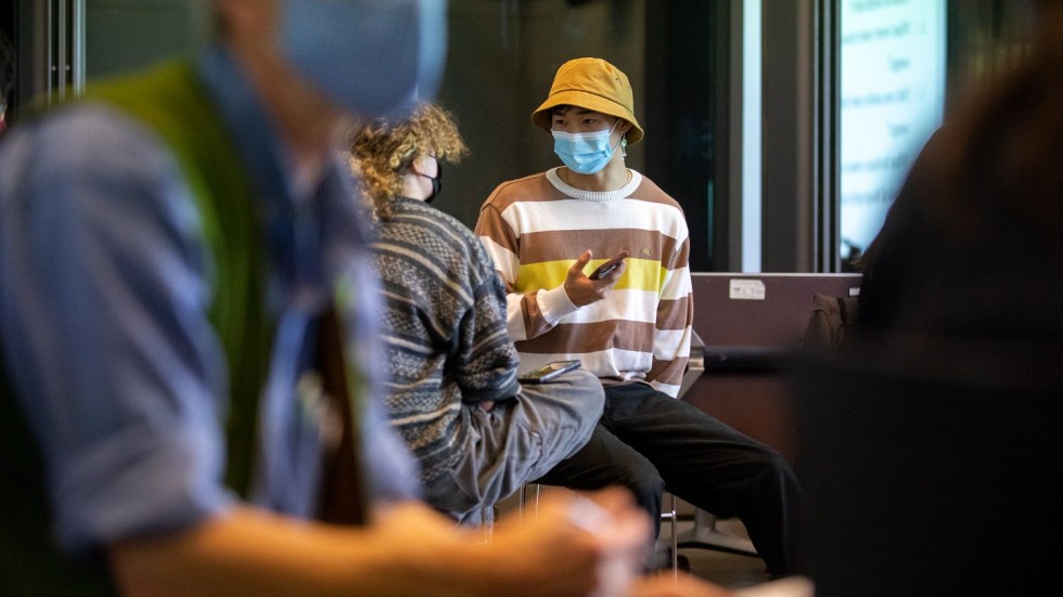 Two masked students in conversation