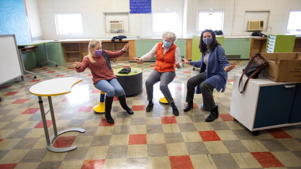 three women sitting on stools with convex bases